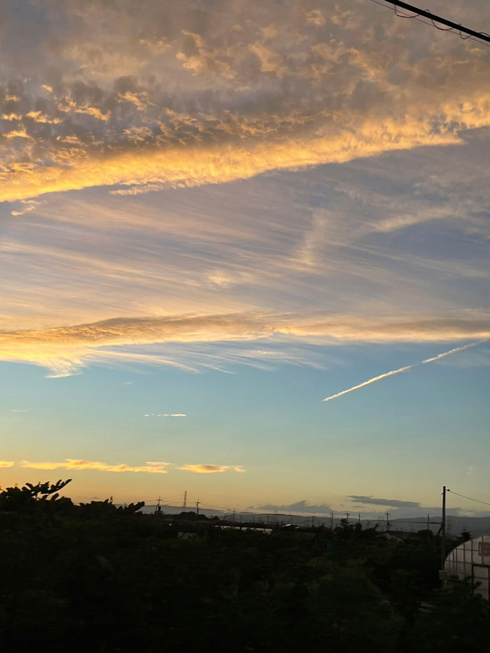夕方の飛行機雲と雲の画像