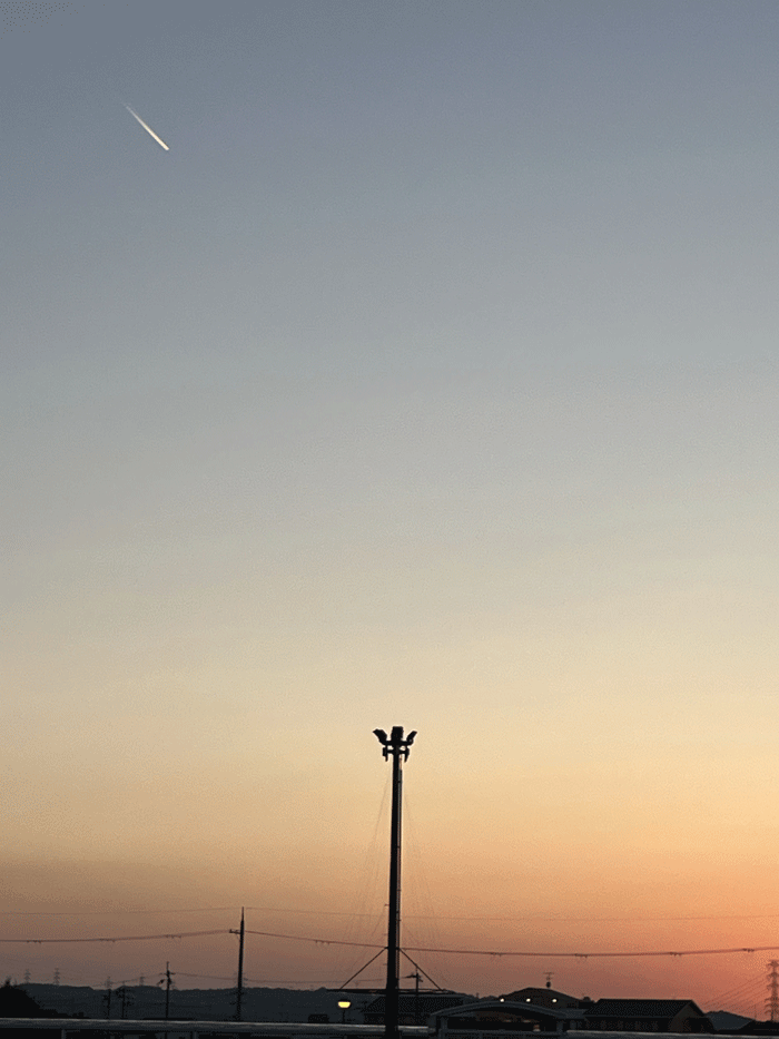 夕焼けと飛行機雲の画像