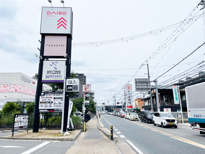 「ダイソー 宇治小倉店」の看板と店舗前の道路の画像