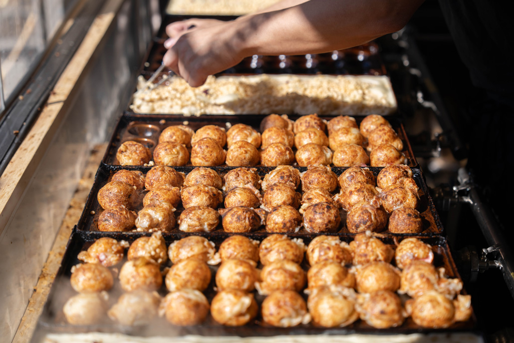 「粉もん屋八近鉄小倉駅前店」で美味しそうなたこ焼を焼いておられる画像