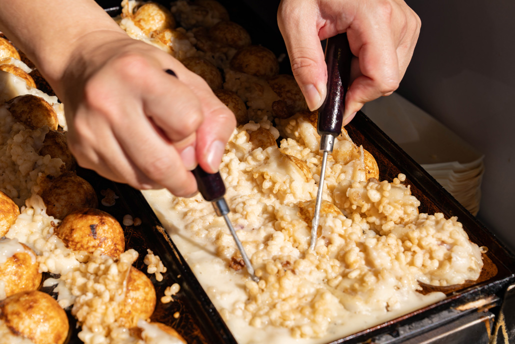 「粉もん屋八近鉄小倉駅前店」でたこ焼を焼いておられる画像